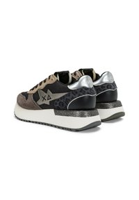 Paio di sneakers nere e marroni con suole a piattaforma bianche, dettagli argentati sul tallone, stampa leopardata e un logo a forma di stella sui lati.