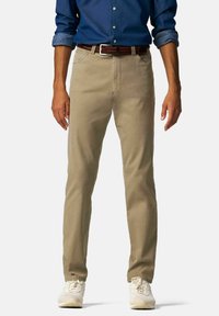 Beige katoenen chinos met een rechte pijp, voorzakken en een bruine gehaakte riem. Gecombineerd met witte sneakers en een blauwe blouse.