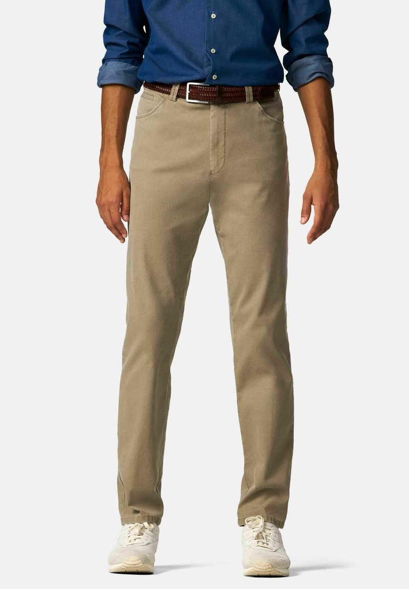Beige katoenen chinos met een rechte pijp, voorzakken en een bruine gehaakte riem. Gecombineerd met witte sneakers en een blauwe blouse.