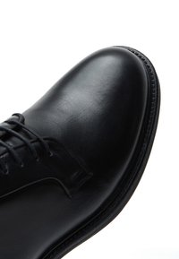 Zwarte leren schoenen met een glad oppervlak, ronde neus en smalle veters. Bevat een schone, gestroomlijnde ontwerpe en subtiele stikselaccenten.