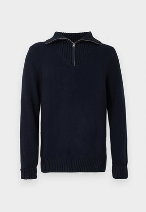Tmavě modrý svetr s imitací límce, polovičním zipem a žebrovanými manžetami a lemem. Obsahuje design ve tvaru V a hladkou texturu.