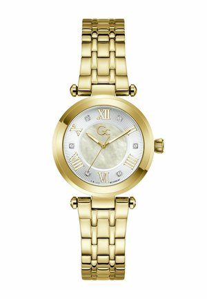 Arany tónusú karóra gyöngyház számlappal, római számokkal, gyémántjelzőkkel és láncszemes szíjjal, az idő 10:10:36-ot mutatva.