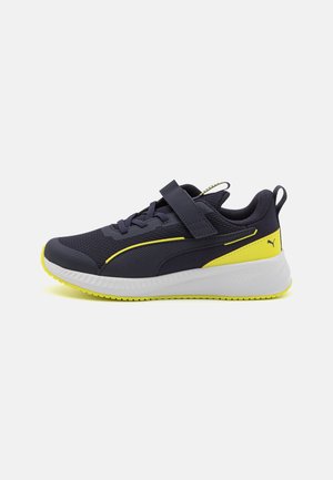 Scarpe da ginnastica Puma con una parte superiore in rete blu navy, dettagli gialli, chiusura a strap e una suola bianca con presa testurizzata.