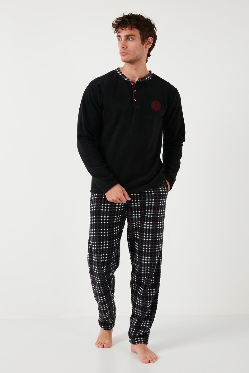 Camiseta térmica negra de manga larga con un cuello de cuadro, combinada con pantalones de franela a cuadros en patrones de color marino, rojo y blanco. Textura suave.