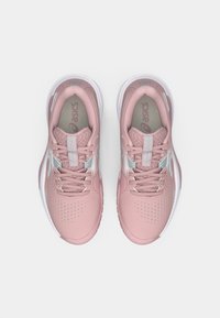 Lys rosa treningssko med teksturert overdel, kontrasterende sølvdetaljer, perforeringer for pusteevne og hvit såle.