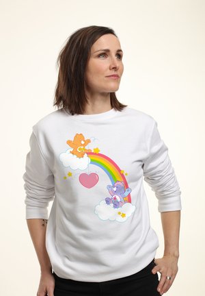 Biała bluza z kolorowymi kartonowymi niedźwiedziami, tęczą, gwiazdami i chmurkami w zabawnym wzorze. Długie rękawy i krój z okrągłym dekoltem.
