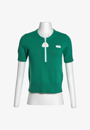 Top verde de punto con mangas cortas, dobladillo y puños acanalados, cremallera blanca en la parte delantera y pequeño parche rectangular en el pecho.