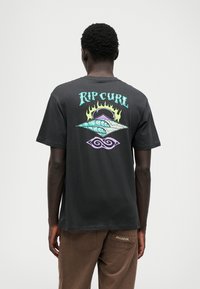 Melnas kokvilnas T-krekls ar krāsainiem grafikiem: teksts "Rip Curl", viļņu dizains un liesmu akcenti aizmugurē. Īsās piedurknes un apaļa kakla izgriezums.