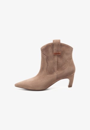 Bruine suède enkelboot met spitse neus, lage hak, decoratieve zijnaad en een achterkant voor eenvoudig aan- en uittrekken. Gladde textuur met matte afwerking.