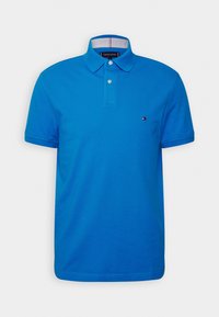 Blå polo skjorta i bomull, med krage, korta ärmar, en knapprad med tre knappar och en liten logodetalj på bröstet.