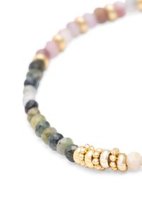 Bracelet avec des perles multicolores facettées et des anneaux de séparation en or brillant sur un fond blanc.