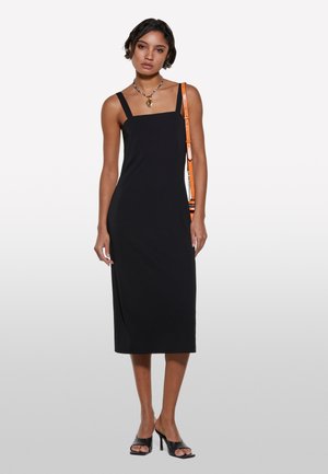 Robe midi noire sans manches avec un décolleté carré, forme ajustée et texture lisse. Accentuée par une sangle orange et des sandales à talons blocs noires.