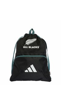 Mochila negra con cordón, fabricada en un tejido duradero, que cuenta con una cinta de acento verde, impresiones de logotipos y un bolsillo frontal con cremallera.