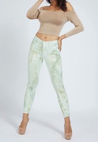 Ljusgröna, marmoriserade slim jeans med hög midja, femfickorsdesign och kontrasterande sömmar. Kombineras med en beigefärgad off-shoulder topp.