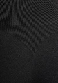 Tissu noir côtelé avec un détail de texture en forme de V près du bas. La surface semble lisse avec un léger éclat dans certaines zones.