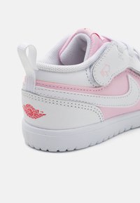 Bijele i ružičaste tenisice od kože i mrežastih materijala, istaknuti Air Jordan logo u crvenoj boji, teksturirana površina i podstavljeni ovratnik za gležnjeve.