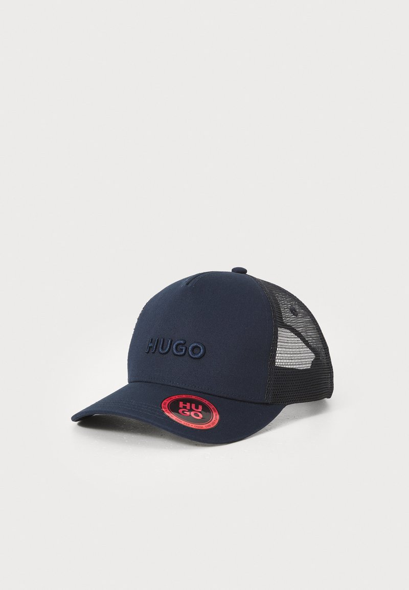 Boné azul-marinho com painéis laterais em malha, aba curva e logótipo bordado "HUGO" na frente. Apresenta um patch redondo com logótipo vermelho na lateral.