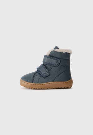 Botas para crianças em pele azul marinho com duas tiras de Velcro, forro em pele sintética e sola em borracha castanha clara. Apresenta um exterior texturizado e um design robusto.