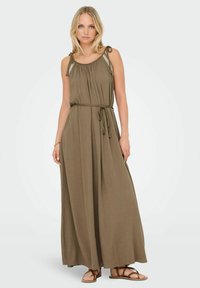 Robe maxi en vert olive, présentant une silhouette fluide, des bretelles ajustables avec des coutures décoratives, et une taille cintrée avec une ceinture tressée.
