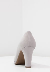 Chaussure à talon haut en suède gris avec un bout pointu et une finition lisse. Dispose d'un talon épais robuste et d'une semelle intérieure rembourrée confortable.
