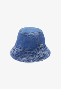 Sombrero de cubo de mezclilla en azul con detalles de costura visibles, corona redonda y ala ancha. Presenta un pequeño logo bordado en el costado.