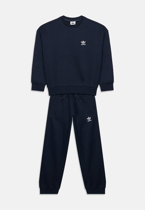 Survêtement Adidas bleu marine avec sweat-shirt col rond et pantalon de survêtement à cordon, tous deux avec logos blancs Adidas Trefoil sur la poitrine gauche et la cuisse.