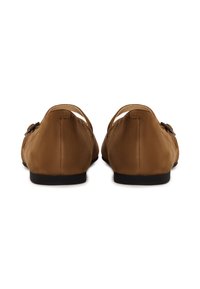 Zapatos planos de ante marrón con punta redonda, una tira delgada en el empeine y un pequeño detalle metálico en el lateral. Suelas negras.