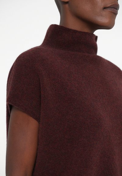 Top de mezcla de lana color marrón con cuello alto y mangas cortas, con una textura suave y costuras mínimas para una silueta limpia.