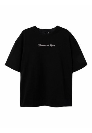 T-shirt en coton noir à manches courtes, coupe ample, avec un texte brodé "Académie des Sports" en police cursive sur la poitrine.