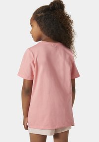 Camiseta de algodón rosa de manga corta con un corte relajado y cuello redondo, que presenta una textura suave y un diseño simple y limpio.