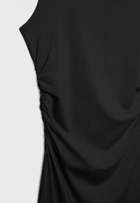 Black dress featuring soft fabric, ruching detail on the side, and a smooth texture. Sleeveless with a relaxed fit.