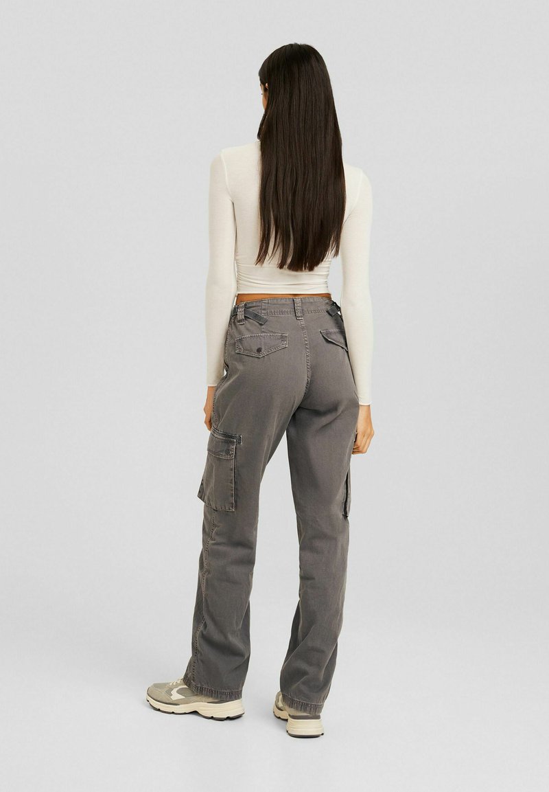 Grijze cargobroek met zijzakken, met een relaxed fit. Gemaakt om te dragen met een strak wit topje. Het materiaal lijkt duurzaam met een textuurafwerking.