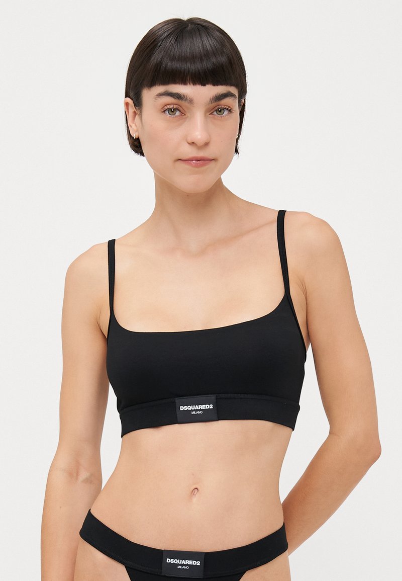 Black bralette in soft fabric with thin straps, rectangular shape, elastic band featuring the DSQUARED2 logo at the bottom.