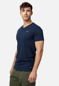 Marineblå bomulds V-hals T-shirt med korte ærmer og et lille logo på brystet. Har standard pasform og blød tekstur.