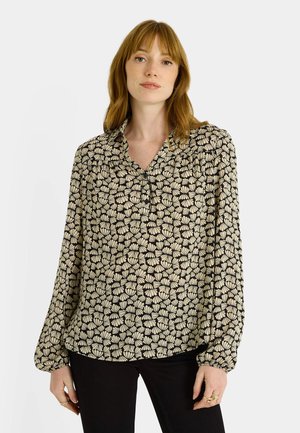 Blusa negra con estampado floral en crema, mangas largas, cuello abotonado y hombros fruncidos. Tela de apariencia ligera y ligeramente texturizada.