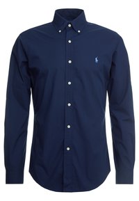 Marinblå långärmad skjorta med knappar gjord av bomull. Har en klassisk krage, vita knappar och en liten blå logotyp på vänster bröst.