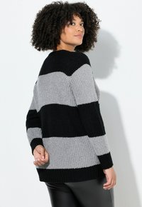 Strickpullover mit horizontalen Streifen in Schwarz und Grau. Lockerer Schnitt mit gerippten Bündchen und Saum, strukturierter Stoff und Rundhalsausschnitt.