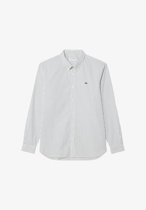 Dolgosleečno belo srajco s tankimi črnimi navpičnimi črtami, ovratnikom z gumbi in majhnim zelenim logotipom krokodila na prsih.