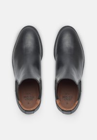 Stivaletti in pelle nera alla caviglia con pannelli laterali elasticizzati, punta arrotondata e fodera interna a contrasto. Presentano dettagli cuciti lungo la suola.