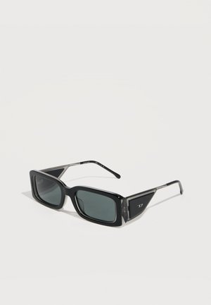 Sorte rektangulære solbriller med mørke linser og sølvaccenterede stænger på en lys baggrund.