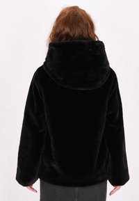 Sort faux fur hoodie med en stor, blød hætte. Har en afslappet pasform, lange ærmer og en glat, plysset tekstur. Ingen synligt metal.
