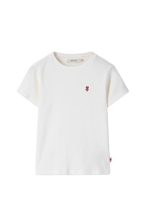 T-shirt blanc à manches courtes côtelé avec col rond et petit emblème de fleur rouge sur le côté gauche de la poitrine.
