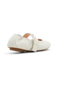 Vita läderballerinaskor med rund tå, elastisk kant och dekorativ rosett. Platt sula, lätt upphöjd häl.