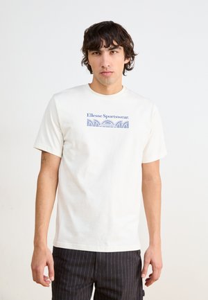 T-shirt crème à manches courtes avec un graphique bleu portant le texte "Ellesse Sportswear" et des motifs de vagues au centre. Coupe décontractée.