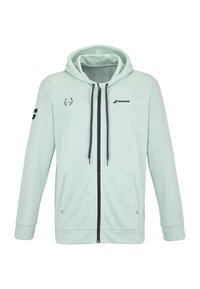 Lys grøn hoodie med lynlås foran, snoretræk i hætten og sidelommer. Har et sort logo på brystet og venstre ærme. Blød stoftekstur.