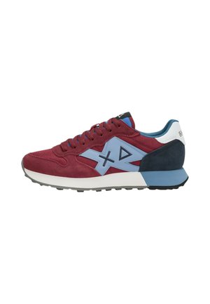 Vista laterale di una sneaker color bordeaux con accenti blu e neri, logo geometrico azzurro chiaro, linguetta sul tallone bianca e suola bianca e blu.
