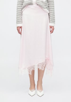 Ροζ μάλλινη midi φούστα με διαγώνιο τελείωμα, διακοσμημένη με λεπτή δαντέλα στο κάτω μέρος. Φοριέται με λευκές γόβες μυτερές στο δάχτυλο.