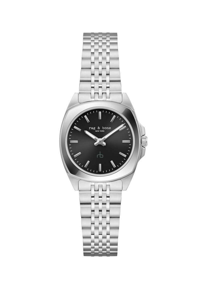 Hõbedane roostevabast terasest kell tekstuuriga rihmaga, must kelladial, hõbedased tunni märgid ja silmapaistev kroon. Brändi nimi "rag & bone" on nähtav.