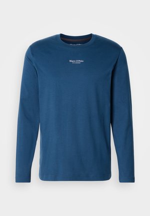 Langarm-T-Shirt aus dunkelblauer Baumwolle. Verfügt über einen klassischen Rundhalsausschnitt und ein kleines weißes Logo auf der Brustmitte. Feine Textur.