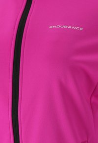 Fuchsia træningsjakke med en glat tekstur, udstyret med en sort lynlås og "ENDURANCE" logo i hvidt på den øverste venstre side.